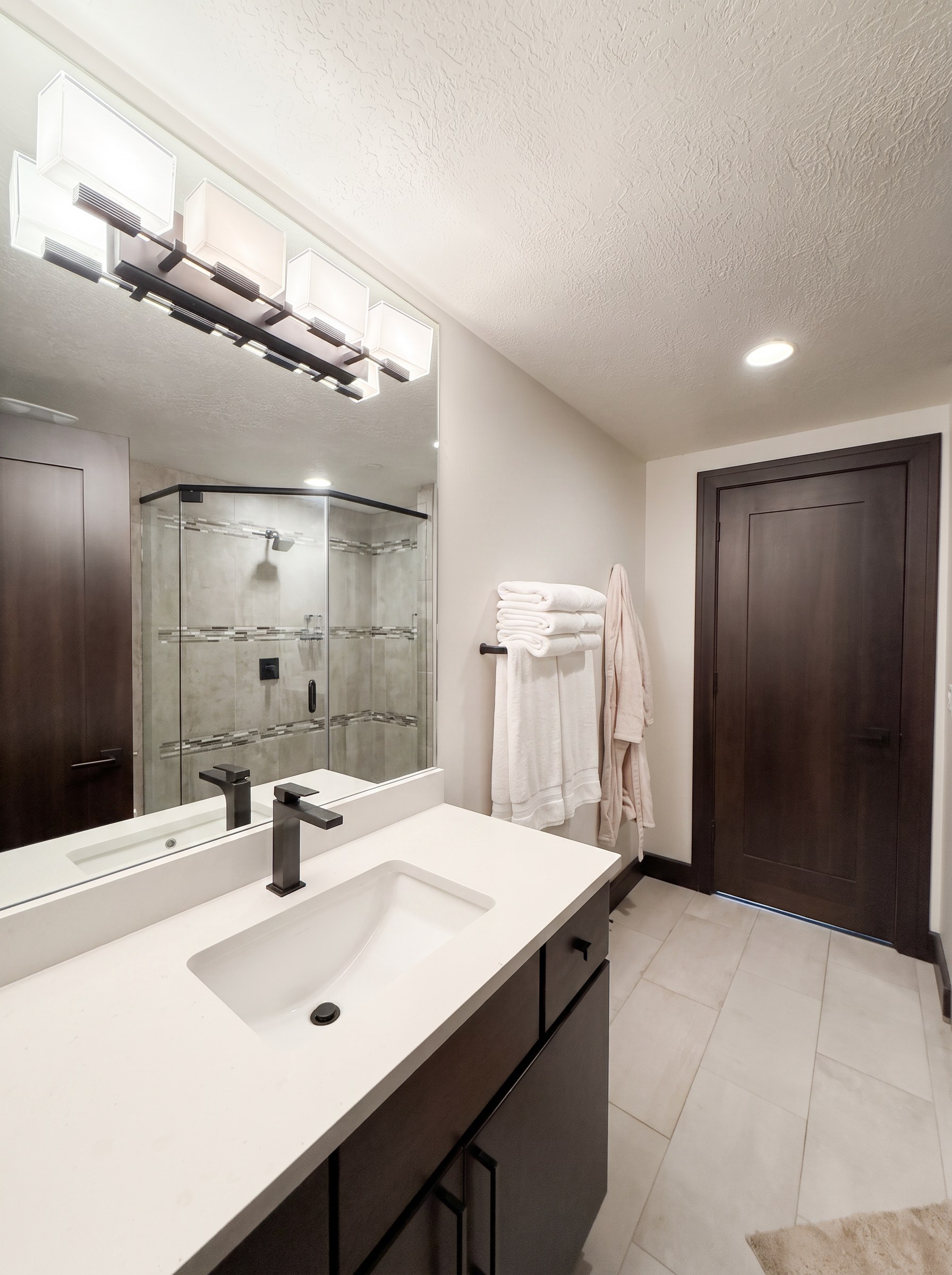 Queen bedroom en suite with a quartz vanity, espresso cabinets, and plush white towels