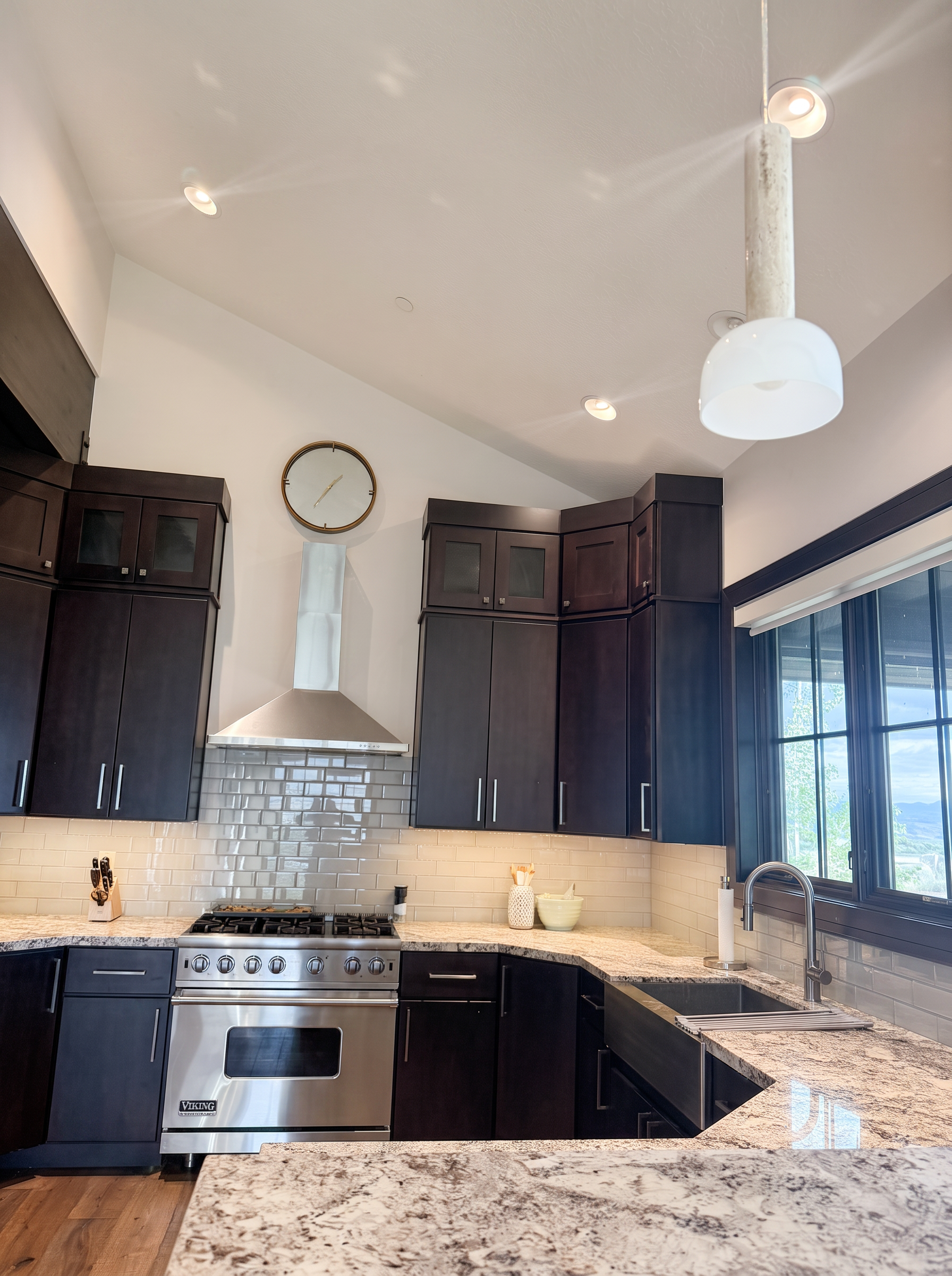 Professional Viking range and farmhouse sink under a mountain-view window