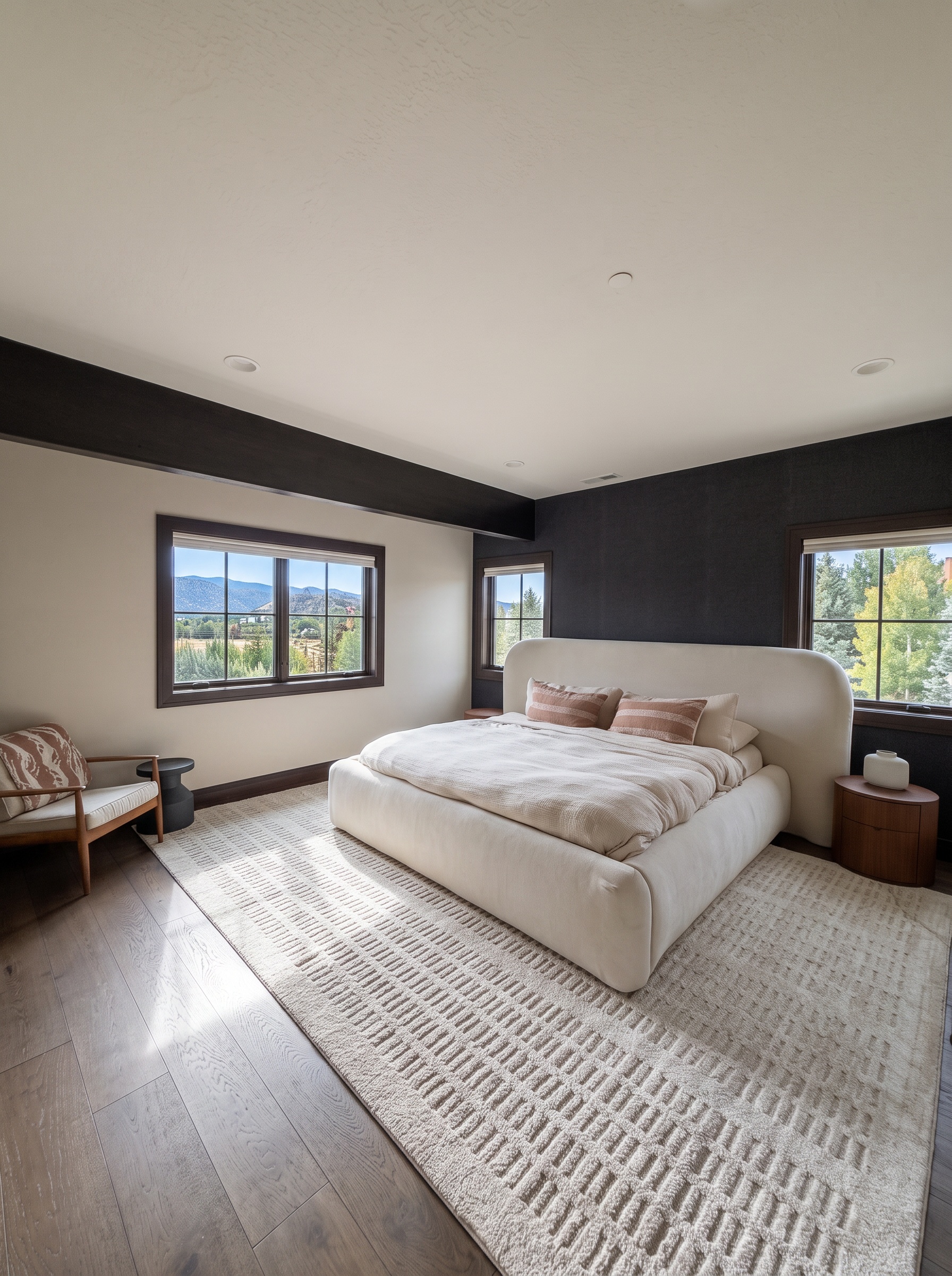 Lower king bedroom with a king-size platform bed, dark accent walls, and a mountain-view window
