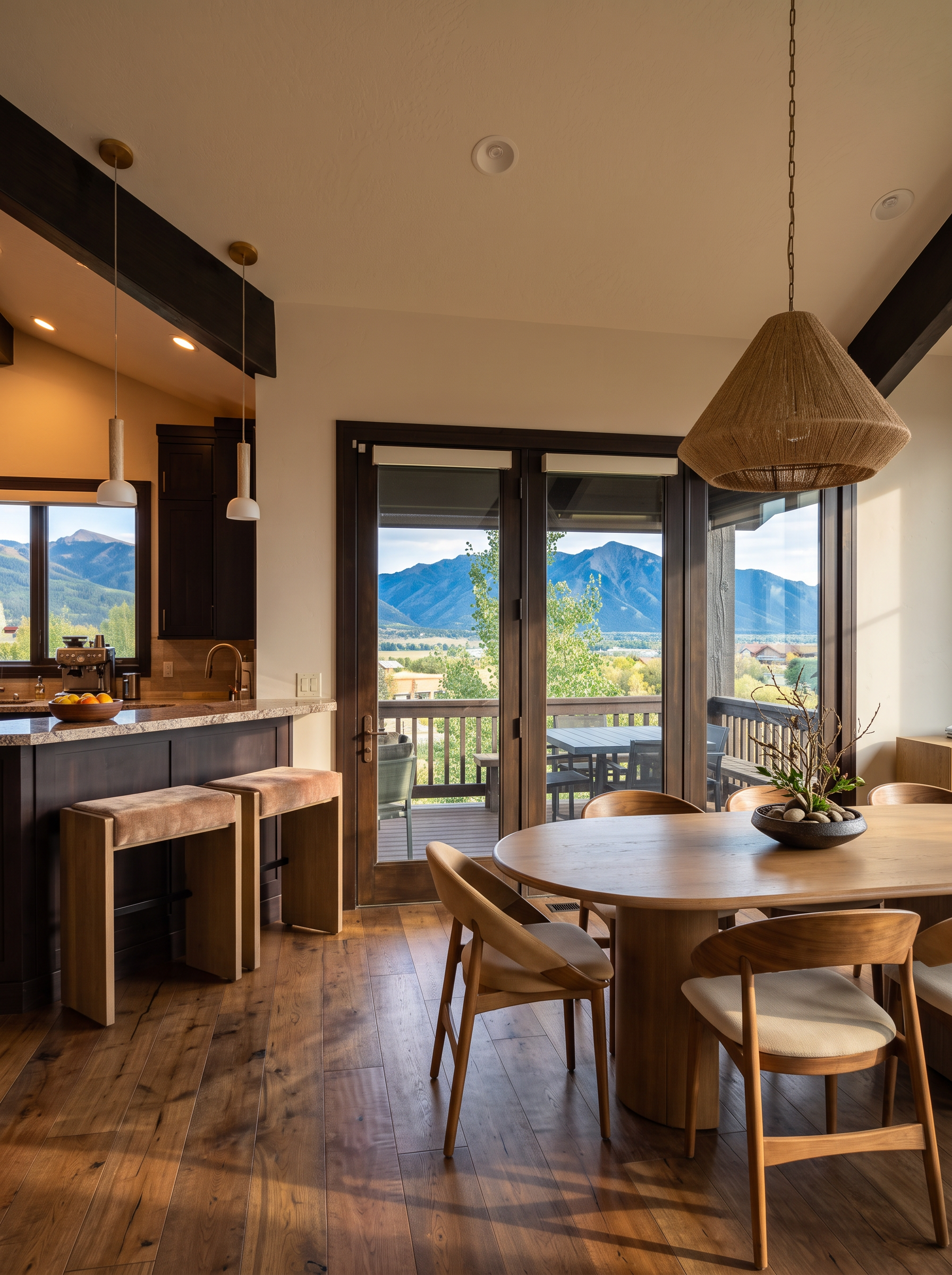 Kay Haus dining table and kitchen bar with doors opening to the mountain-view deck