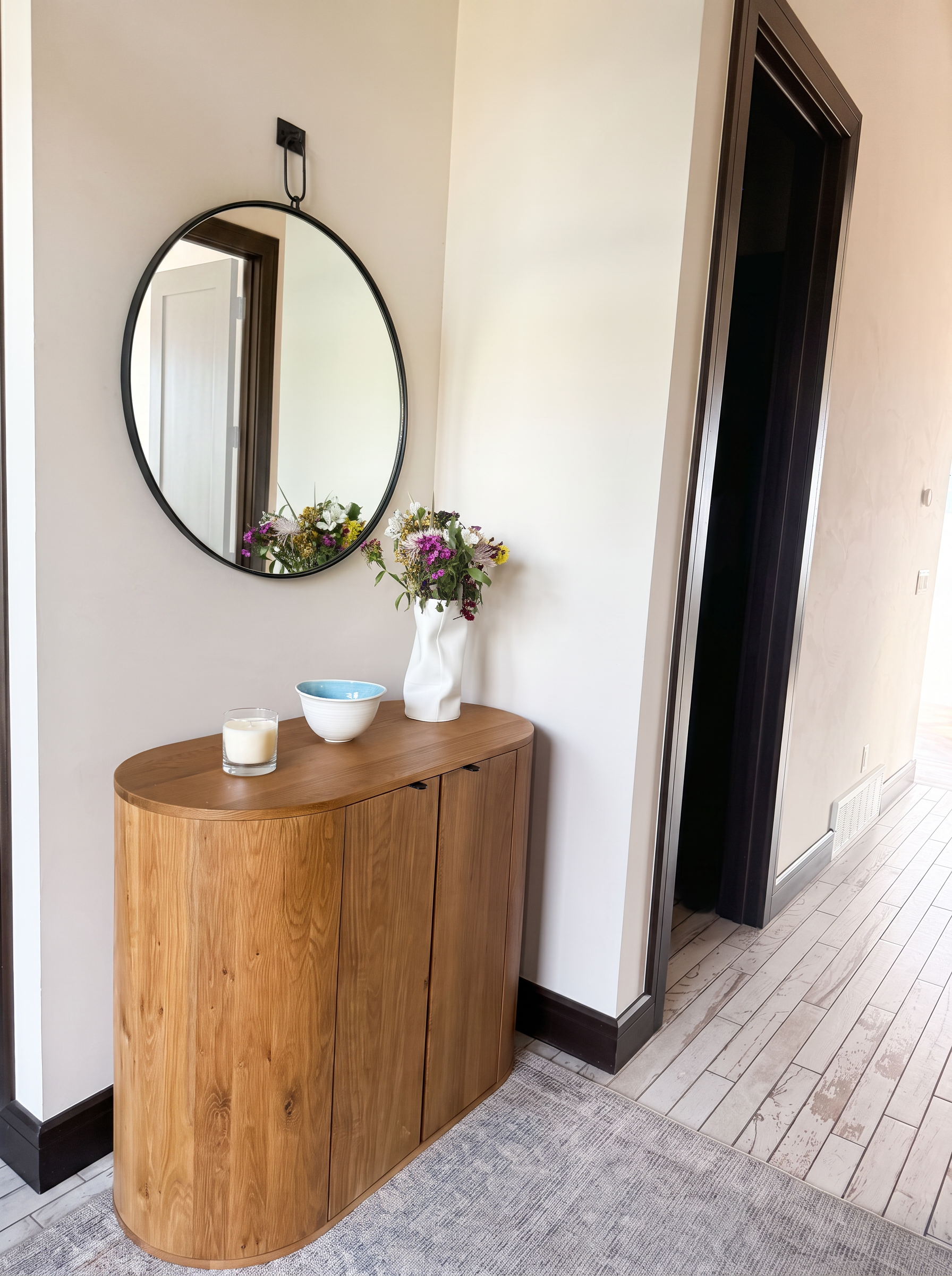 Entry console with oak cabinet, round mirror and fresh flowers